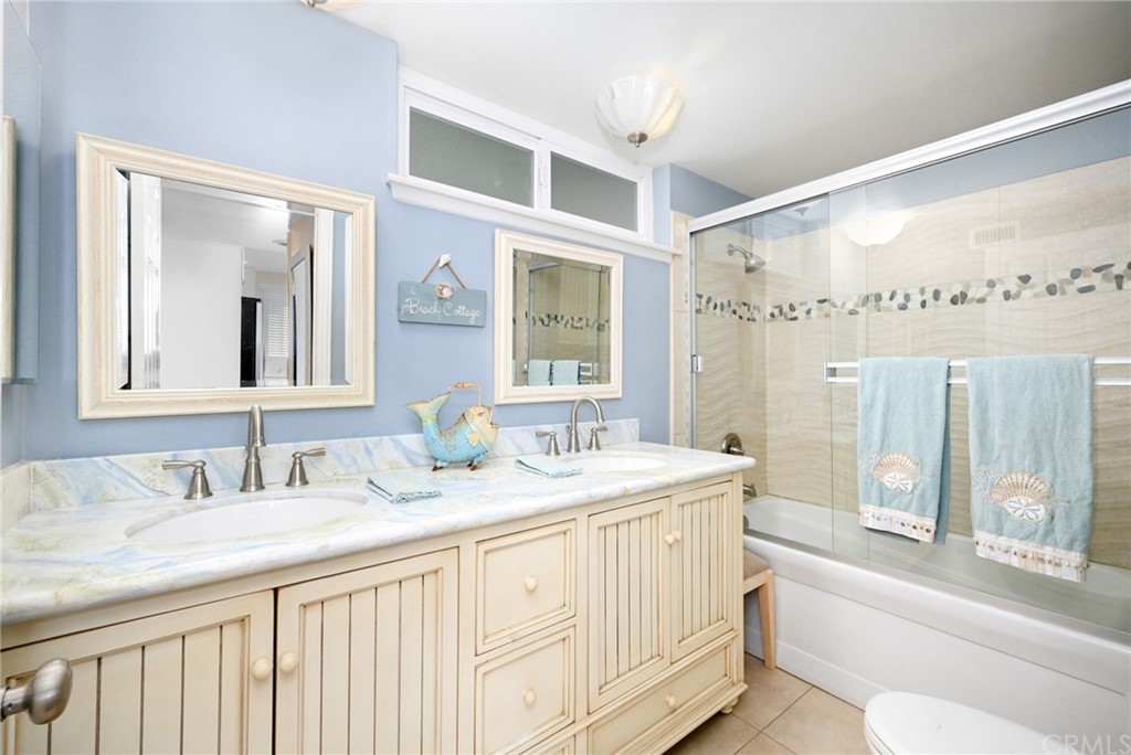 5100 Seashore Drive Newport Beach, CA 92663 - Photo 50 of 67 a bathroom with a granite countertop double vanity sink a mirror and a bathtub