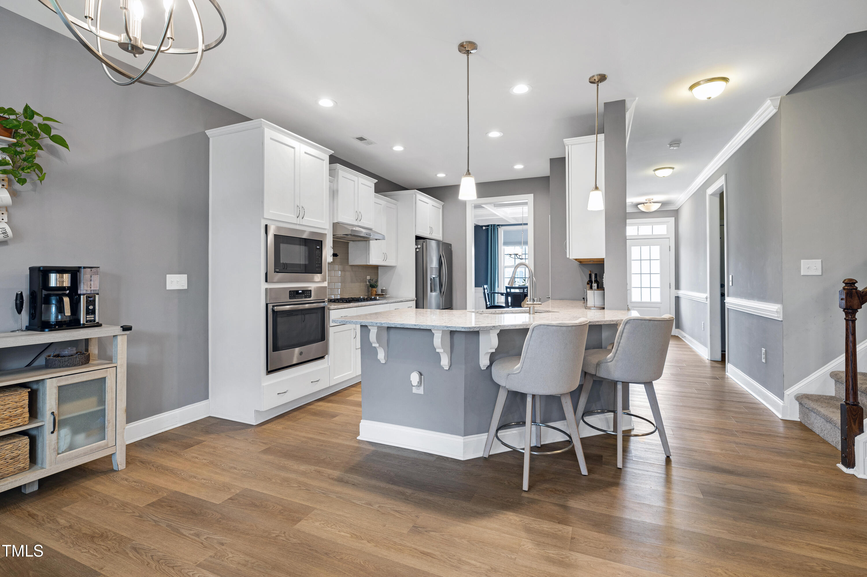 1417 Slate Ridge Road Knightdale, NC 27545 - Photo 11 of 66 a view of a dining room with furniture a kitchen and chandelier