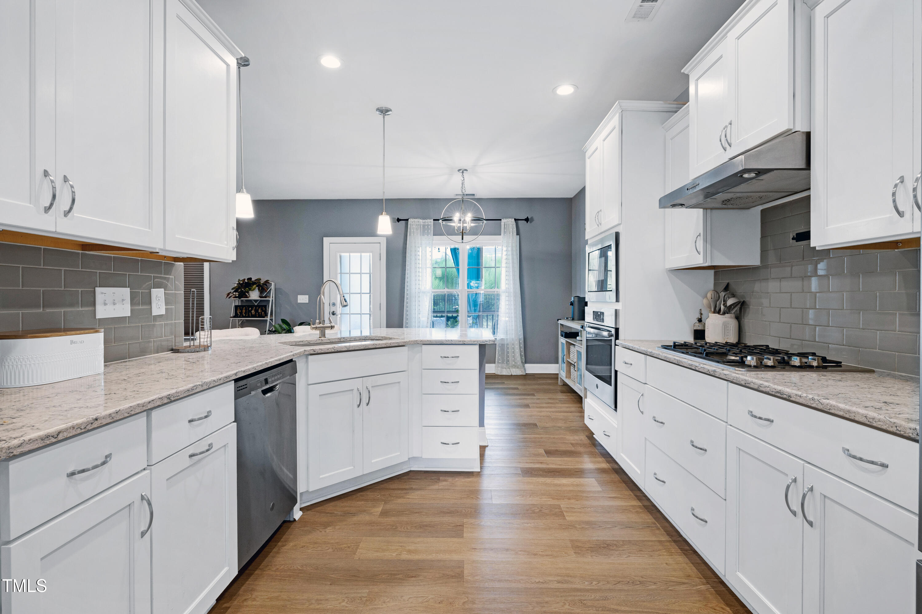 1417 Slate Ridge Road Knightdale, NC 27545 - Photo 14 of 66 a large kitchen with stainless steel appliances granite countertop a lot of counter space and wooden floors