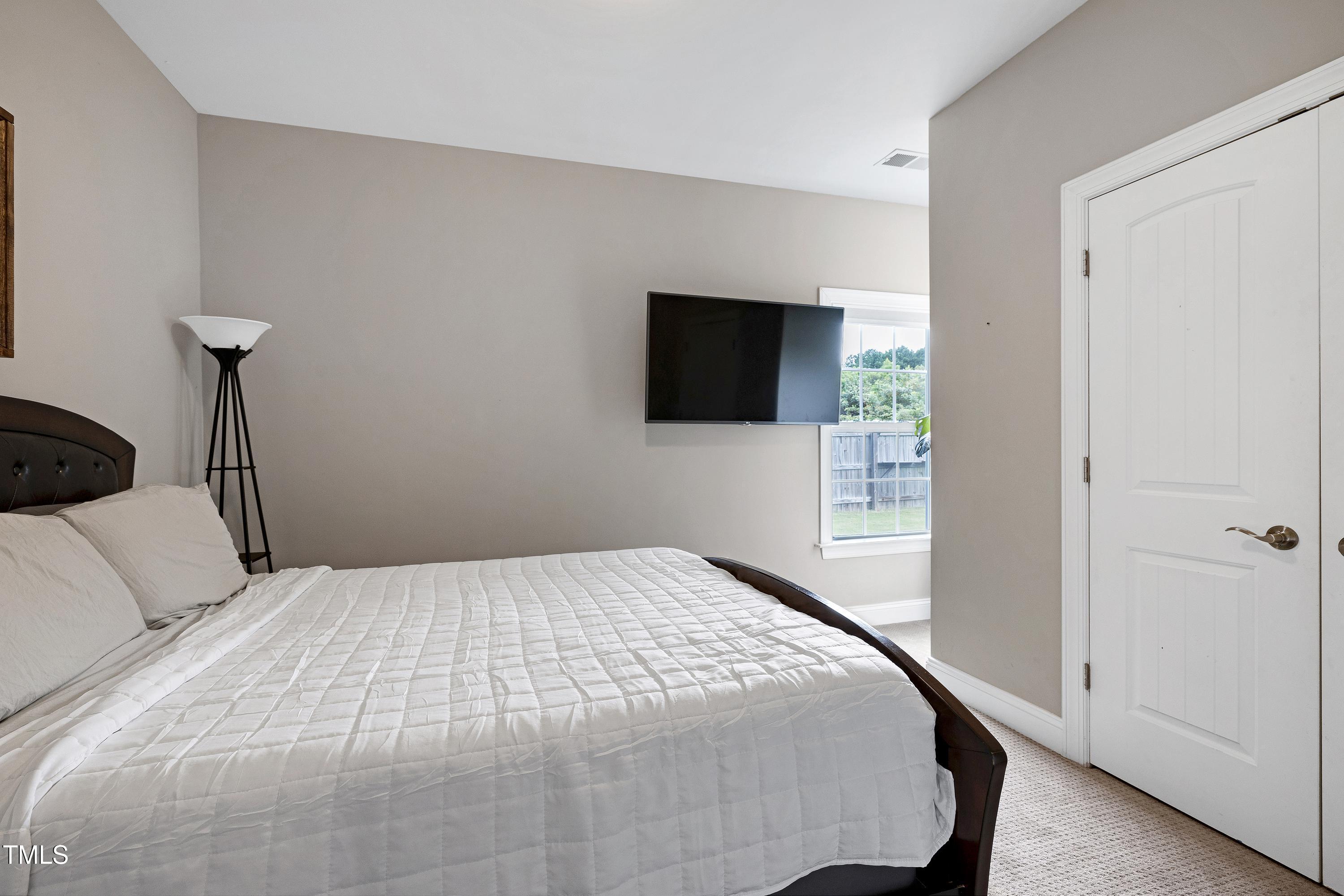 1417 Slate Ridge Road Knightdale, NC 27545 - Photo 21 of 66 a bedroom with a bed and a flat screen tv