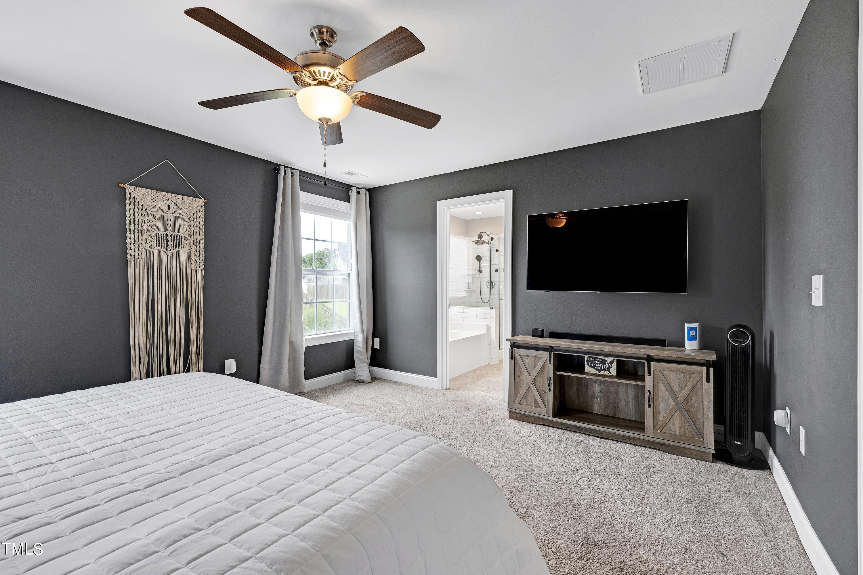 1417 Slate Ridge Road Knightdale, NC 27545 - Photo 23 of 66 a bedroom with a bed and a flat screen tv