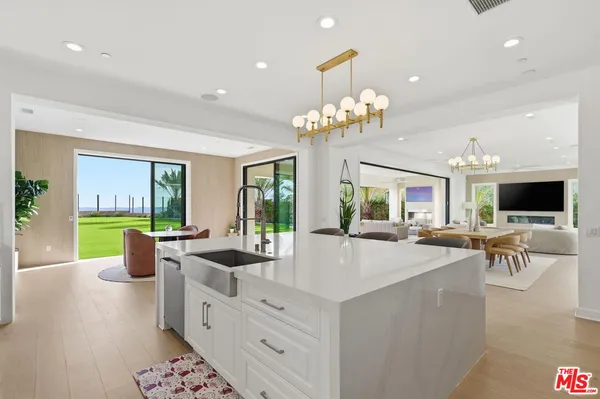a living room with furniture kitchen view and a large window