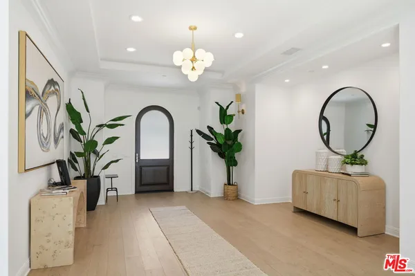 a living room with furniture chandelier and a mirror