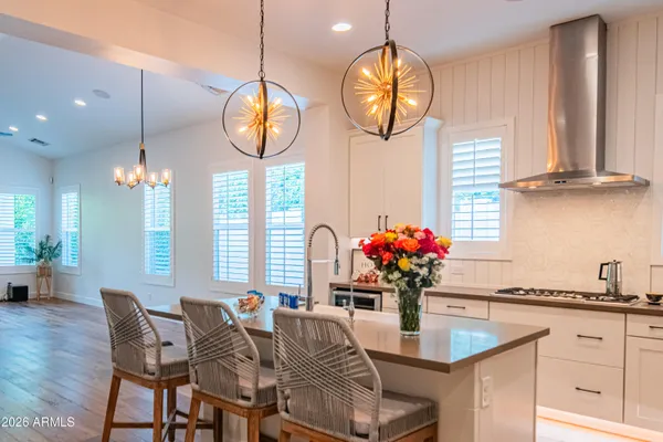 a kitchen with stainless steel appliances granite countertop a sink a stove and a wooden floors