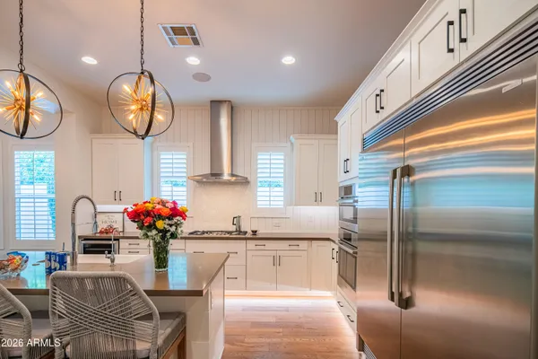 a kitchen with granite countertop a table chairs stove and wooden floor