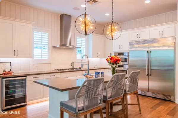 a kitchen with stainless steel appliances granite countertop a sink dishwasher a dining table chairs and chandelier
