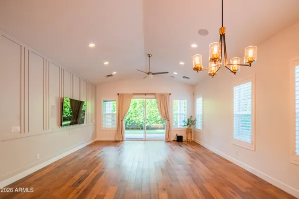 a view of a room with wooden floor a ceiling fan and window