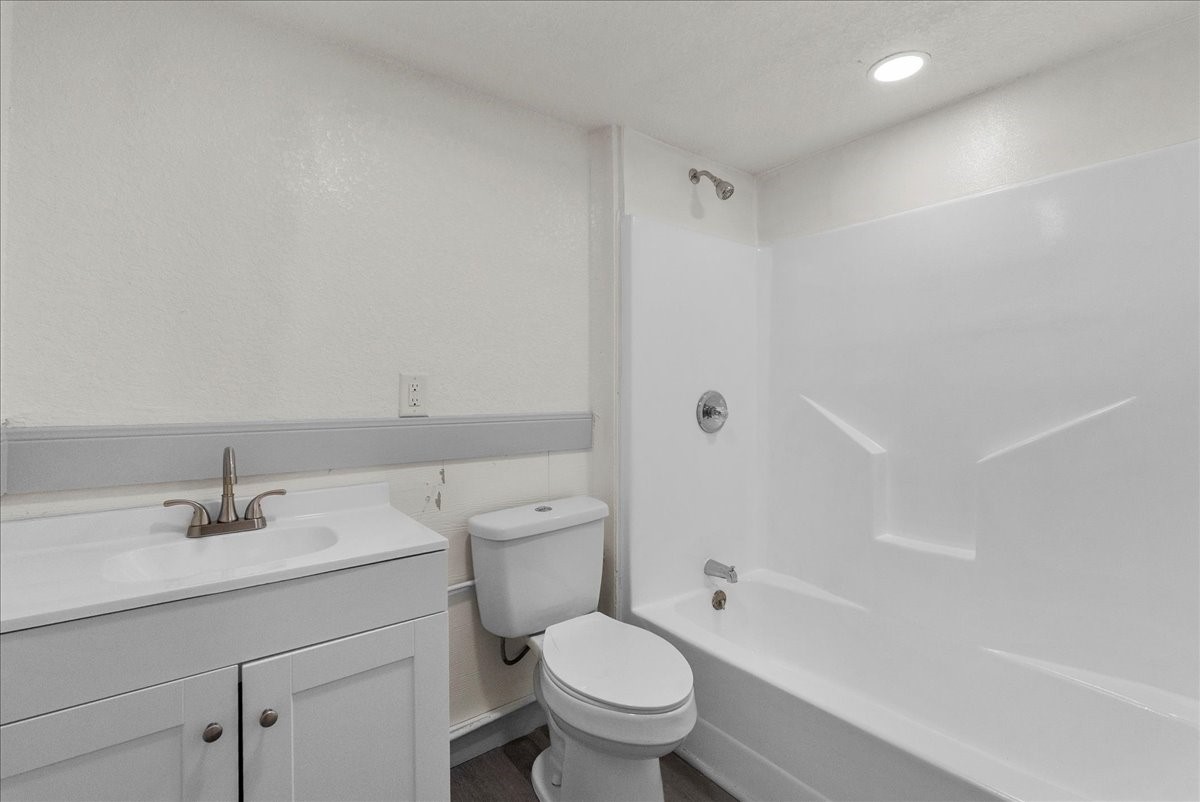 515 Thunder Road Surfside Beach, TX 77541 - Photo 19 of 31 This is a modern bathroom featuring a clean white design, with a shower-tub combo, a sleek vanity with storage, and a contemporary faucet. The space is well-lit with recessed lighting, offering a fresh and functional feel.