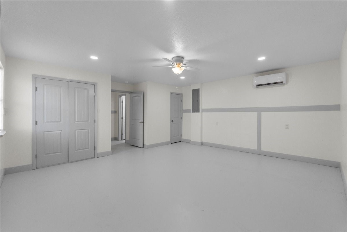 515 Thunder Road Surfside Beach, TX 77541 - Photo 23 of 31 This spacious, neutral-toned room features a ceiling fan, recessed lighting, and an air conditioning unit. It includes double doors and additional storage, making it ideal for versatile use.