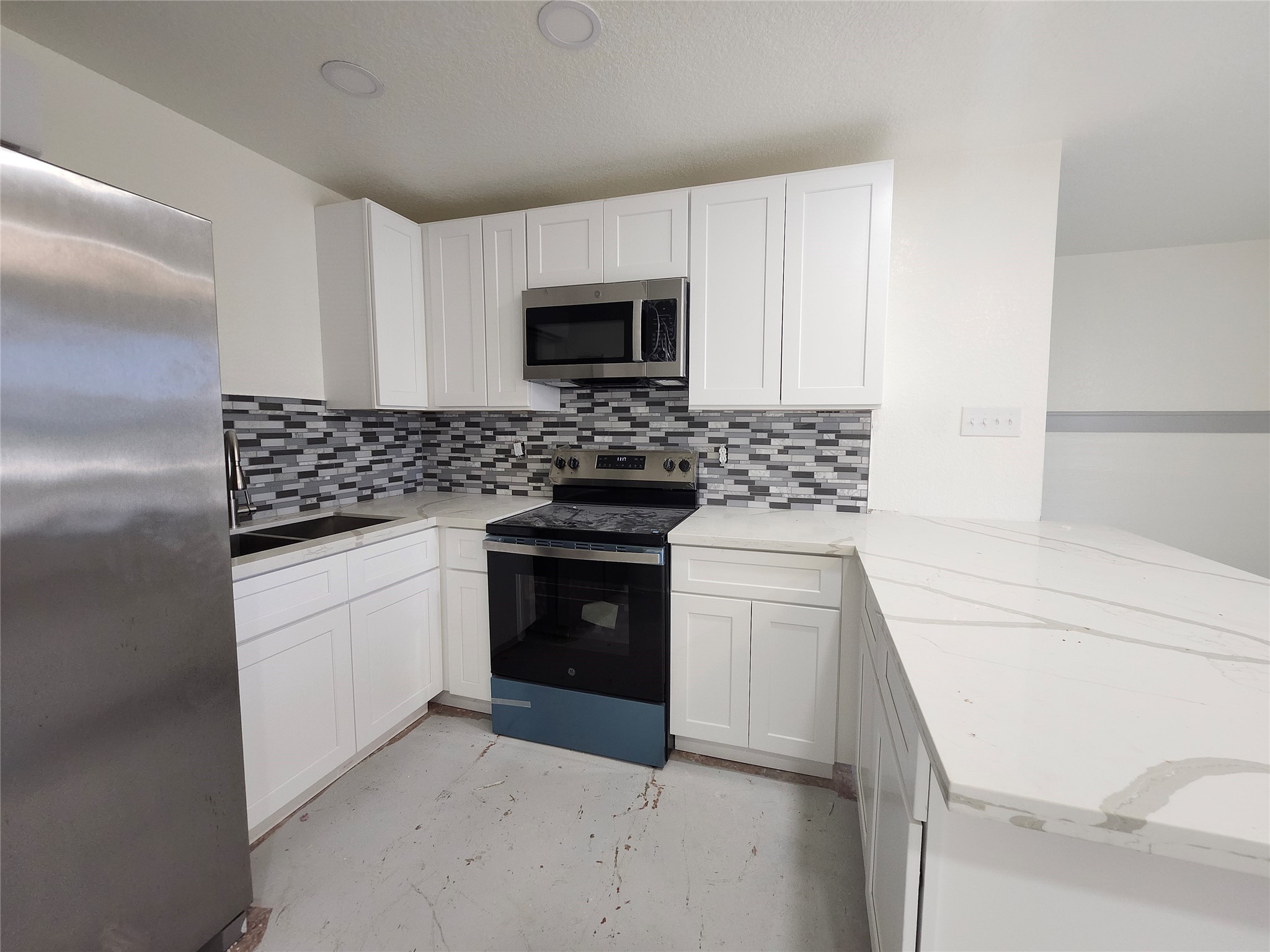515 Thunder Road Surfside Beach, TX 77541 - Photo 10 of 31 The kitchen has stainless refrigerator, sink, stove and microwave.