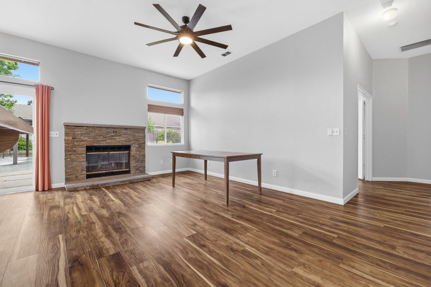 969 Colson Way Galt, CA 95632 - Photo 17 of 38 a view of an empty room with wooden floor fireplace and a window
