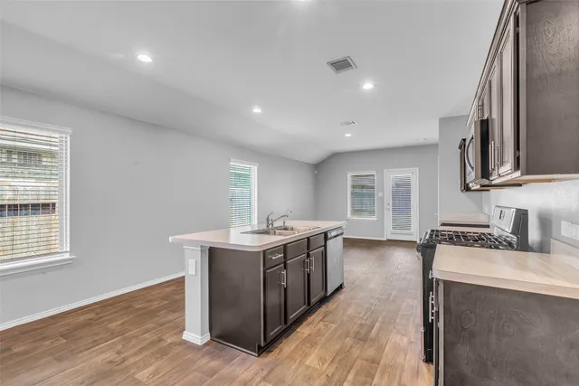 a kitchen with stainless steel appliances granite countertop a sink stove and cabinets
