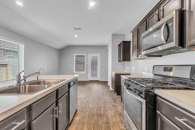 a kitchen with a appliances cabinets and a sink