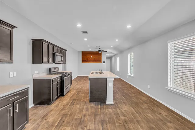 a kitchen with a sink and wooden floor