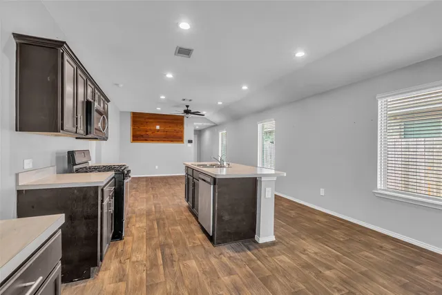 a big room with chandelier fan and windows