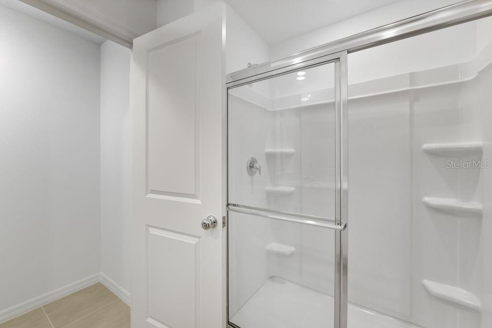 13235 Commons Avenue Parrish, FL 34219 - Photo 16 of 37 a bathroom with a glass shower door
