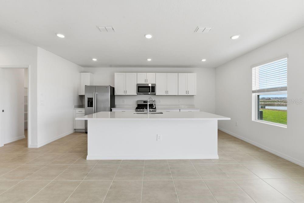 13235 Commons Avenue Parrish, FL 34219 - Photo 2 of 37 a view of kitchen with stainless steel appliances refrigerator sink and cabinets