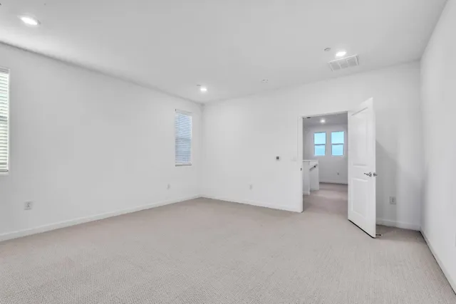 an empty room with a bathroom and mirror