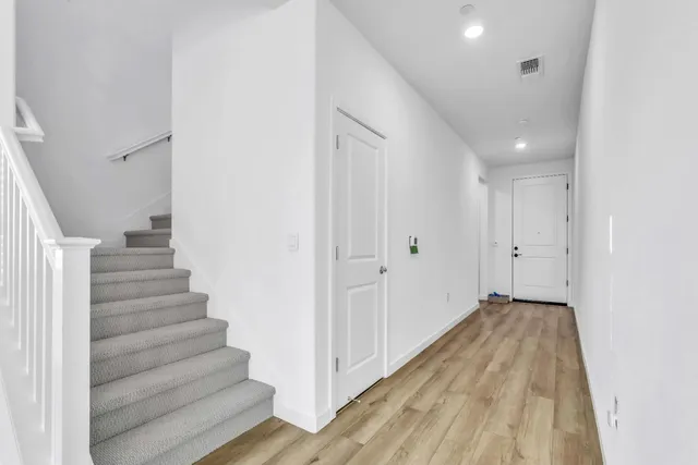 a view of a hallway with wooden floor and entryway