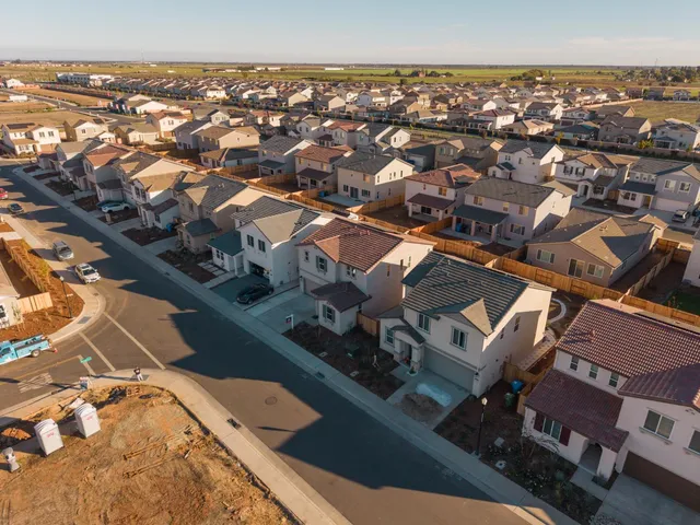 an aerial view of residential houses with city view