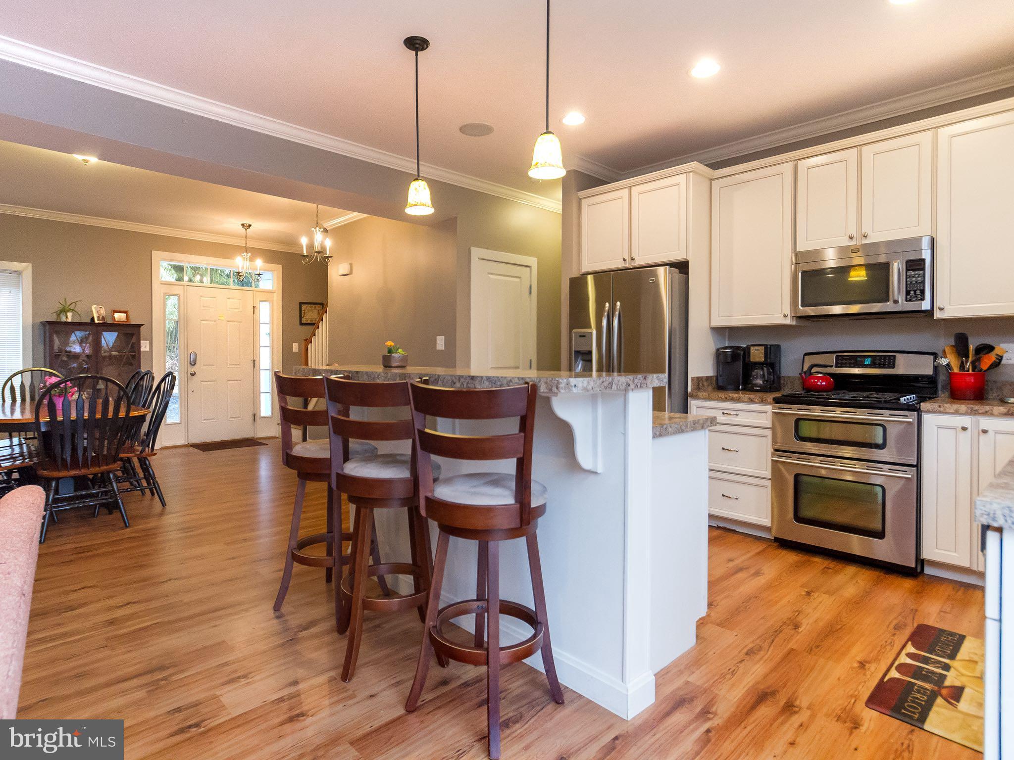 535 Monkton Road Monkton, MD 21111 - Photo 8 of 30 a kitchen with stainless steel appliances granite countertop a refrigerator a stove top oven a sink dishwasher and a dining table with wooden floor