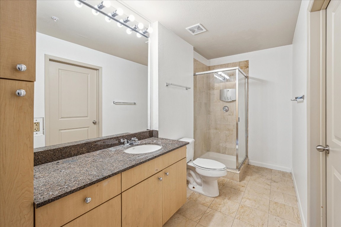3505 Sage Road, Unit 2710 Houston, TX 77056 - Photo 13 of 23 a bathroom with a granite countertop sink a toilet a mirror and shower