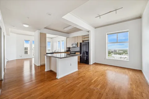 a view of open kitchen with window and wooden floor