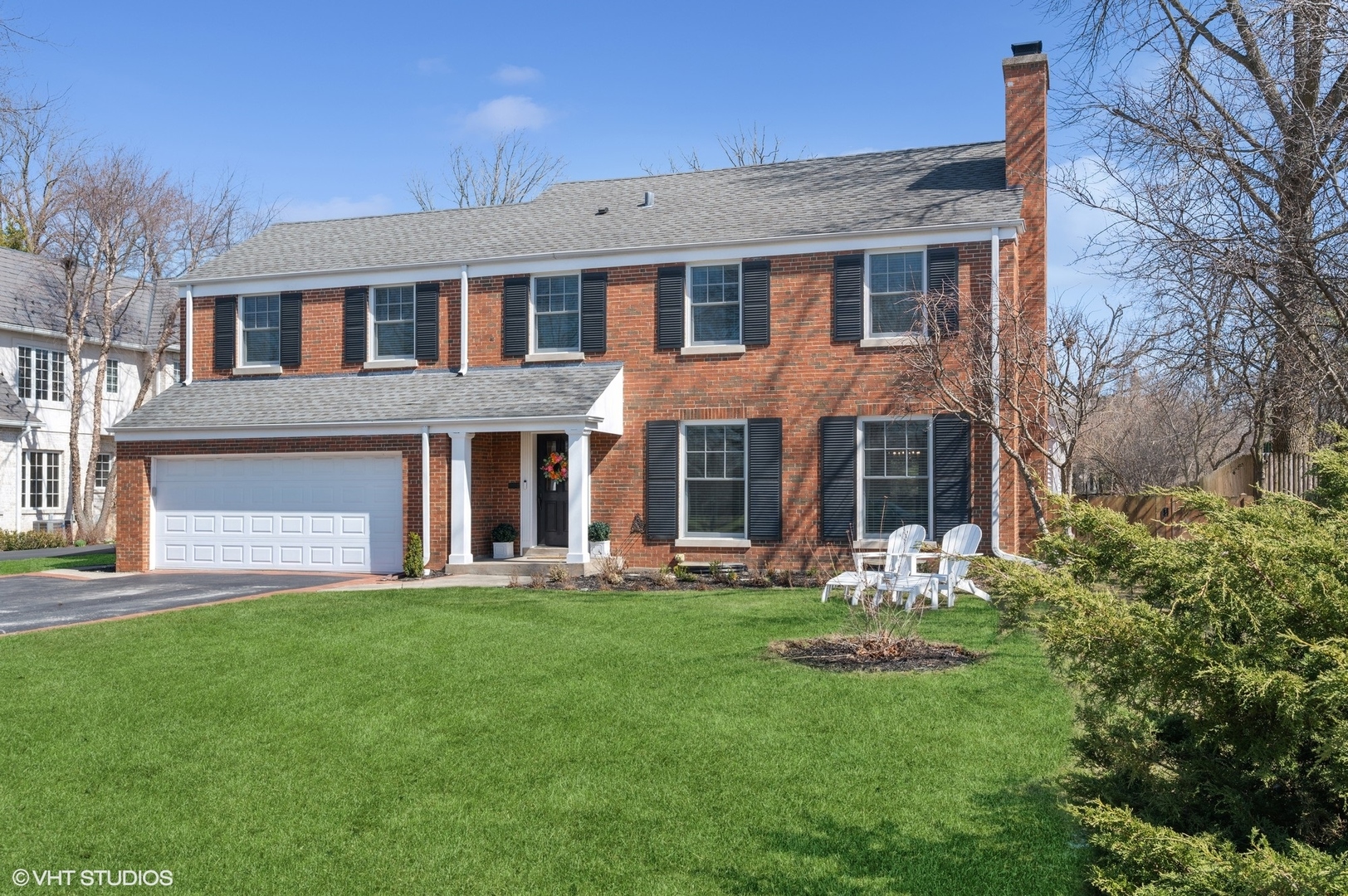 a front view of a house with an garden and trees