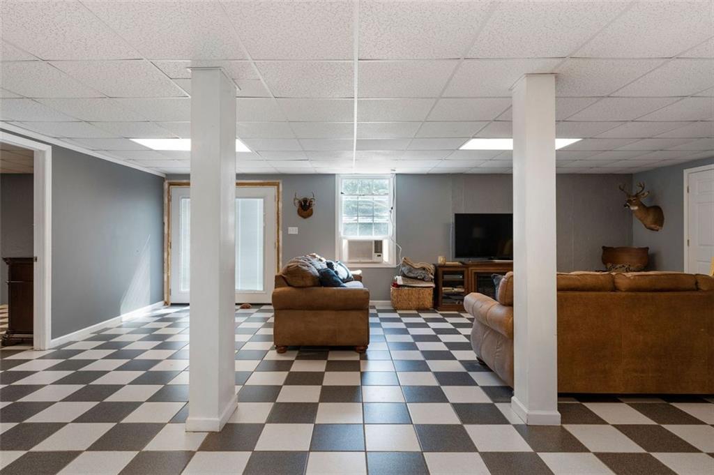 1211 Bellview Road Rockmart, GA 30153 - Photo 31 of 42 a living room with a black white checkered floor with a gaming machine and dining chairs