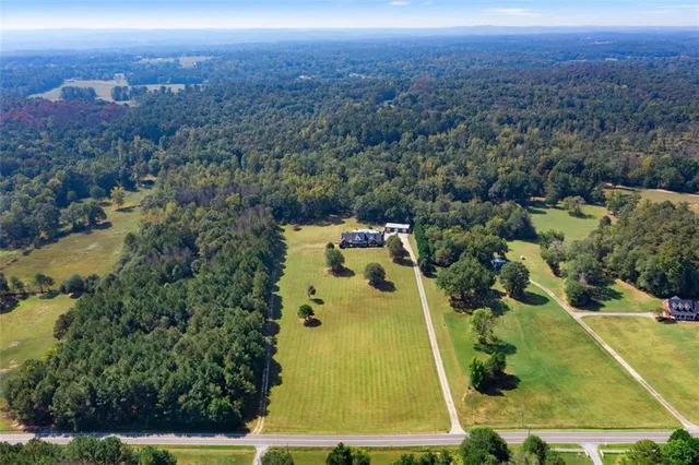 an aerial view of residential houses with outdoor space and trees