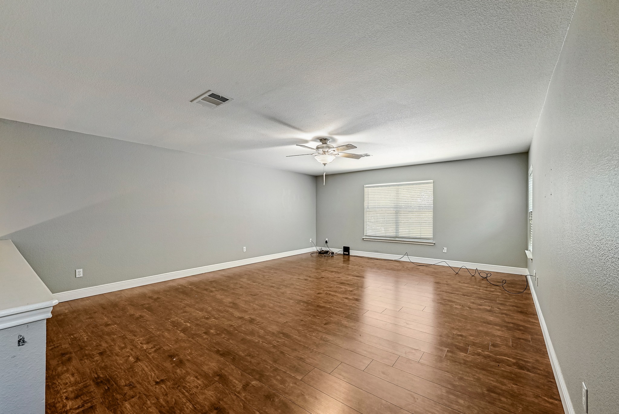 104 North Sumac Lane Georgetown, TX 78633 - Photo 25 of 40 Rich hardwood floors complement neutral walls in this versatile great room, ready for personalization.