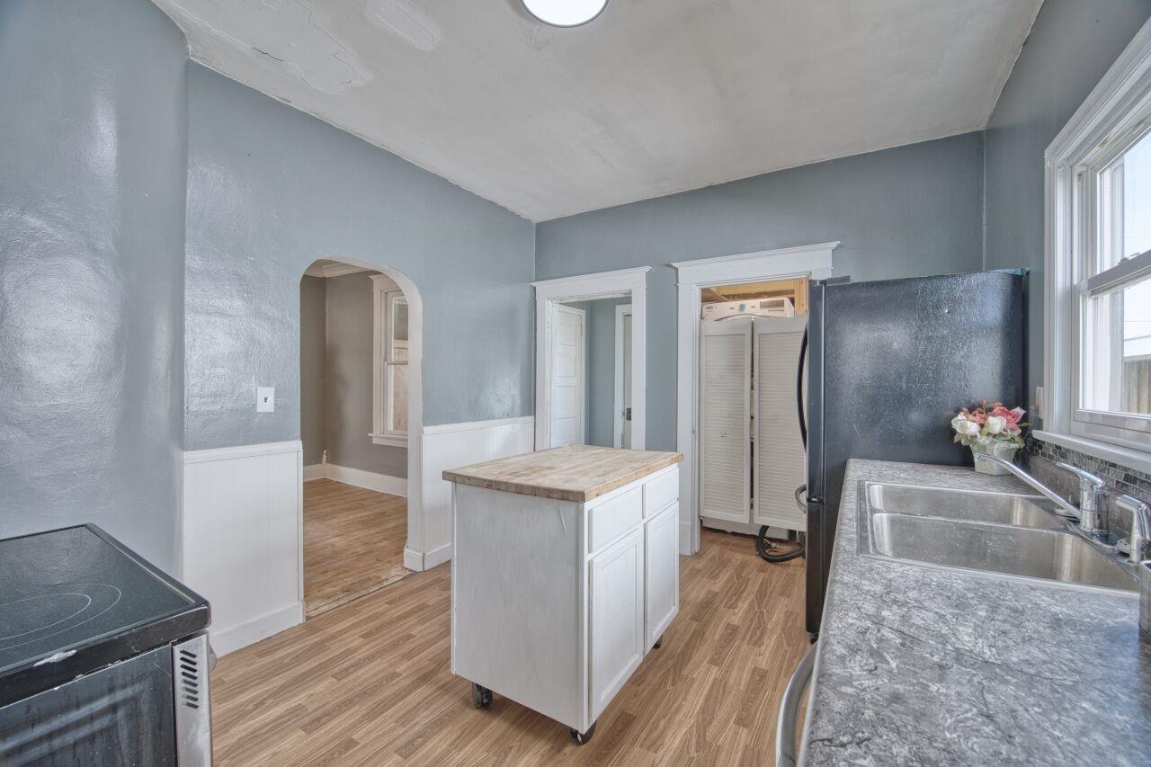 25 3rd Street Southwest Chisholm, MN 55719 - Photo 12 of 44 Kitchen featuring arched walkways, light wood-style floors, white cabinets, wood counters, and range with electric stovetop