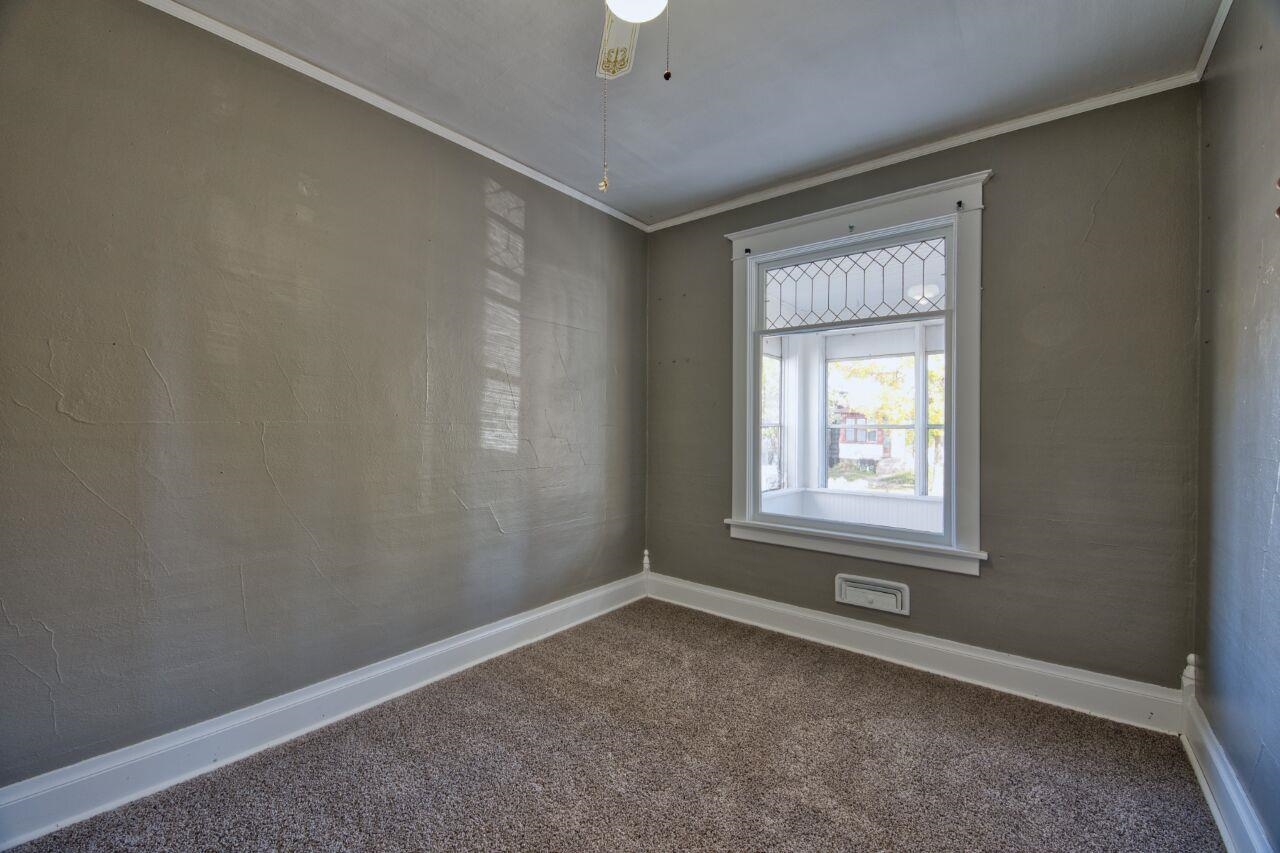 25 3rd Street Southwest Chisholm, MN 55719 - Photo 14 of 44 Carpeted spare room with ornamental molding and ceiling fan