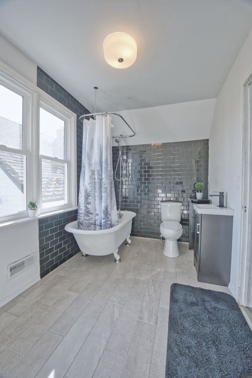 25 3rd Street Southwest Chisholm, MN 55719 - Photo 20 of 44 Bathroom featuring tile walls, vanity, and a combined bath / shower with freestanding tub