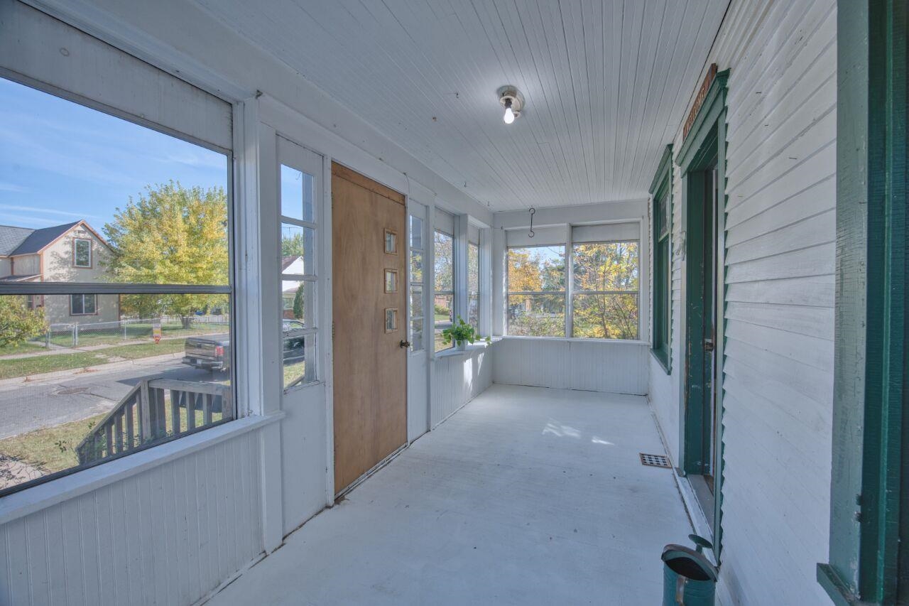 25 3rd Street Southwest Chisholm, MN 55719 - Photo 2 of 44 Unfurnished sunroom with unfinished concrete floors and wood walls