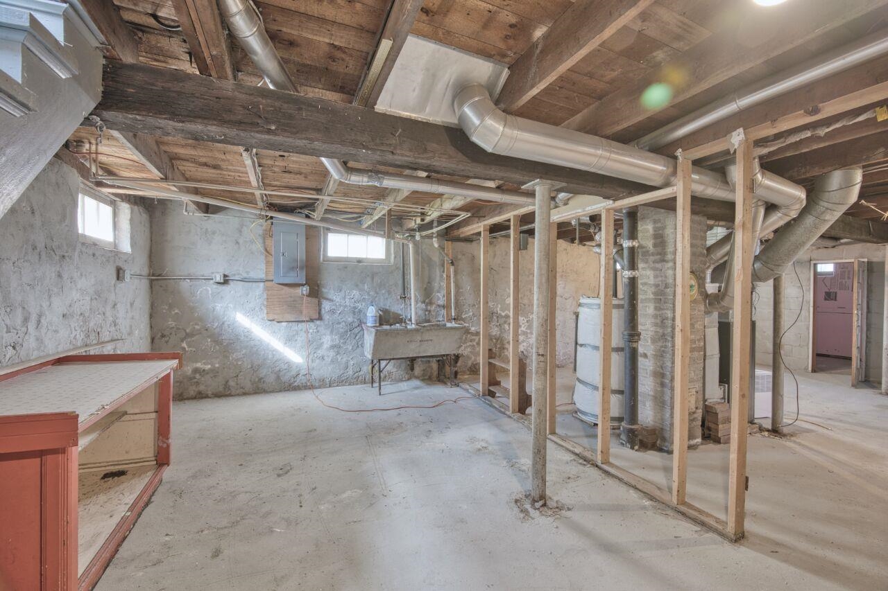 25 3rd Street Southwest Chisholm, MN 55719 - Photo 21 of 44 Basement featuring electric panel, strapped water heater, and heating unit