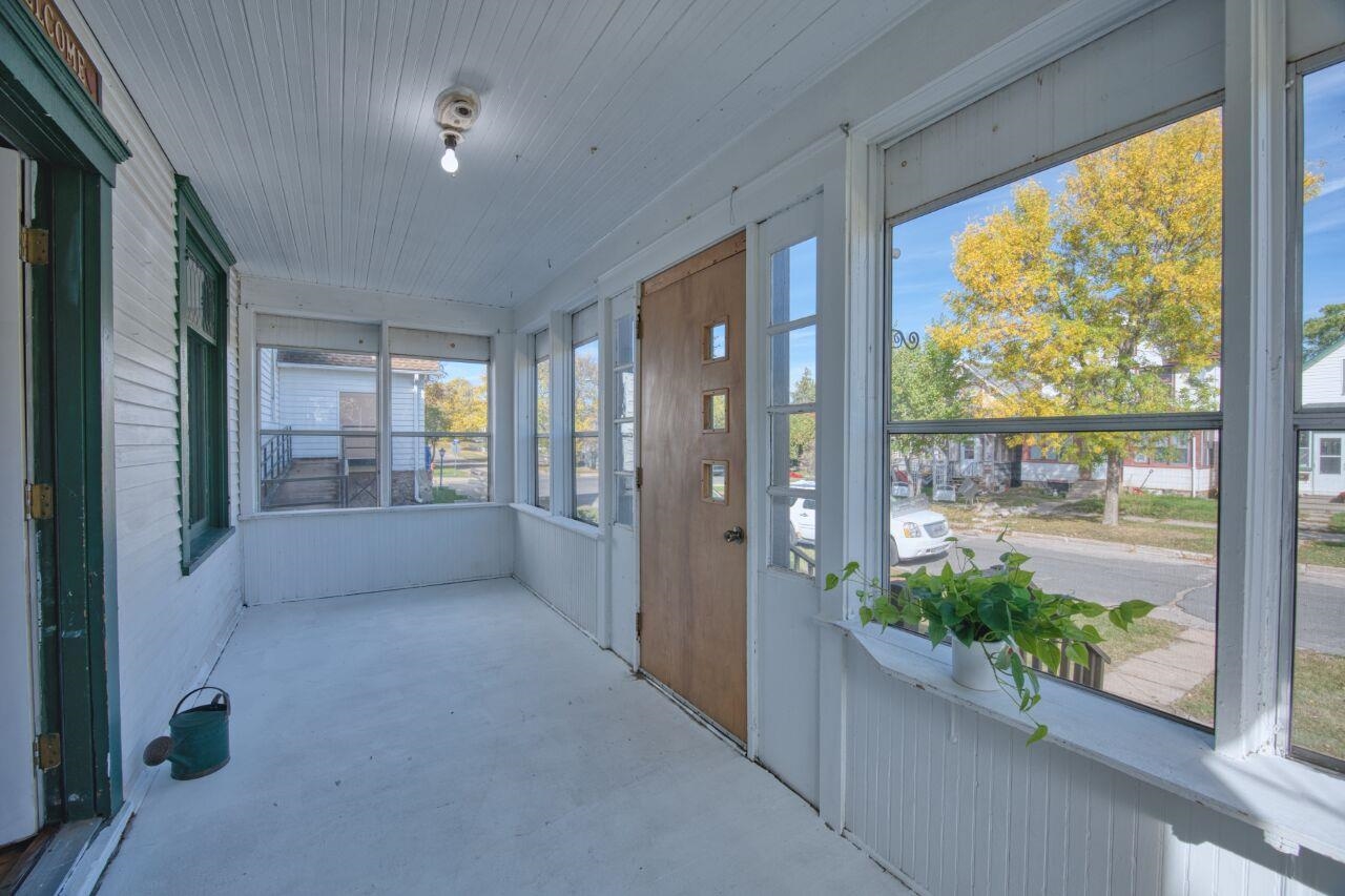 25 3rd Street Southwest Chisholm, MN 55719 - Photo 3 of 44 Unfurnished sunroom featuring concrete floors and wood walls