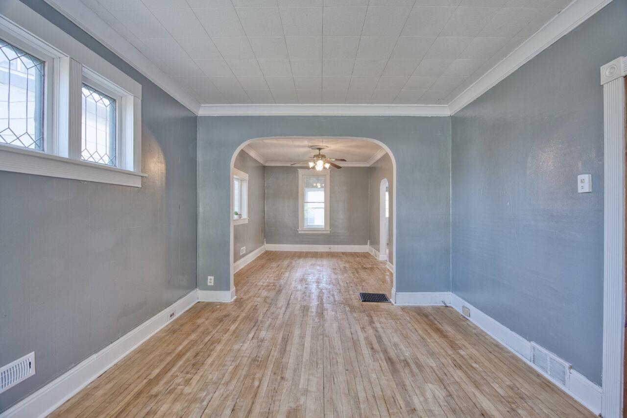 25 3rd Street Southwest Chisholm, MN 55719 - Photo 5 of 44 Spare room featuring ornamental molding, ceiling fan, hardwood / wood-style flooring, and arched walkways