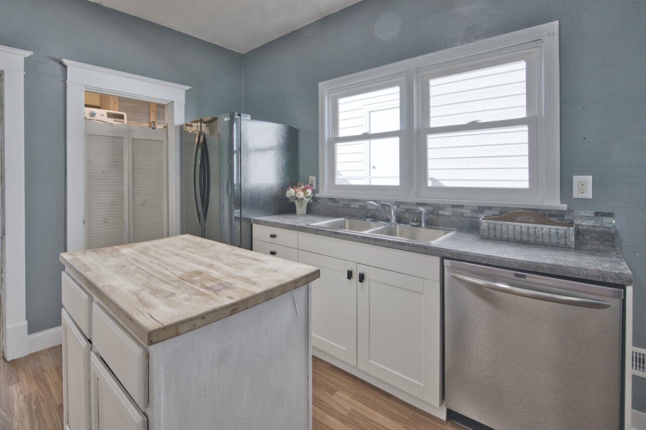 25 3rd Street Southwest Chisholm, MN 55719 - Photo 9 of 44 Kitchen with dishwasher, freestanding refrigerator, butcher block counters, a kitchen island, and light wood finished floors