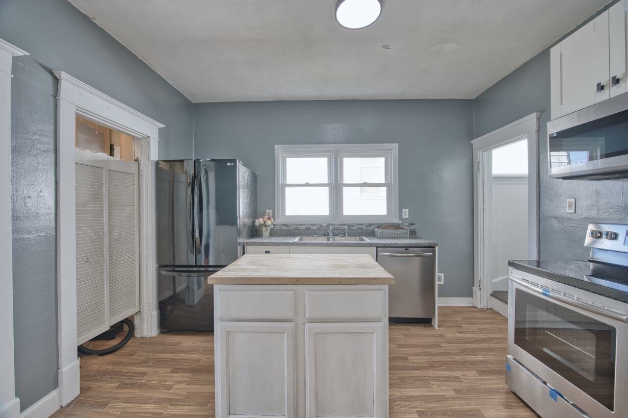 25 3rd Street Southwest Chisholm, MN 55719 - Photo 10 of 44 Kitchen with stainless steel appliances, white cabinets, butcher block counters, and light wood finished floors