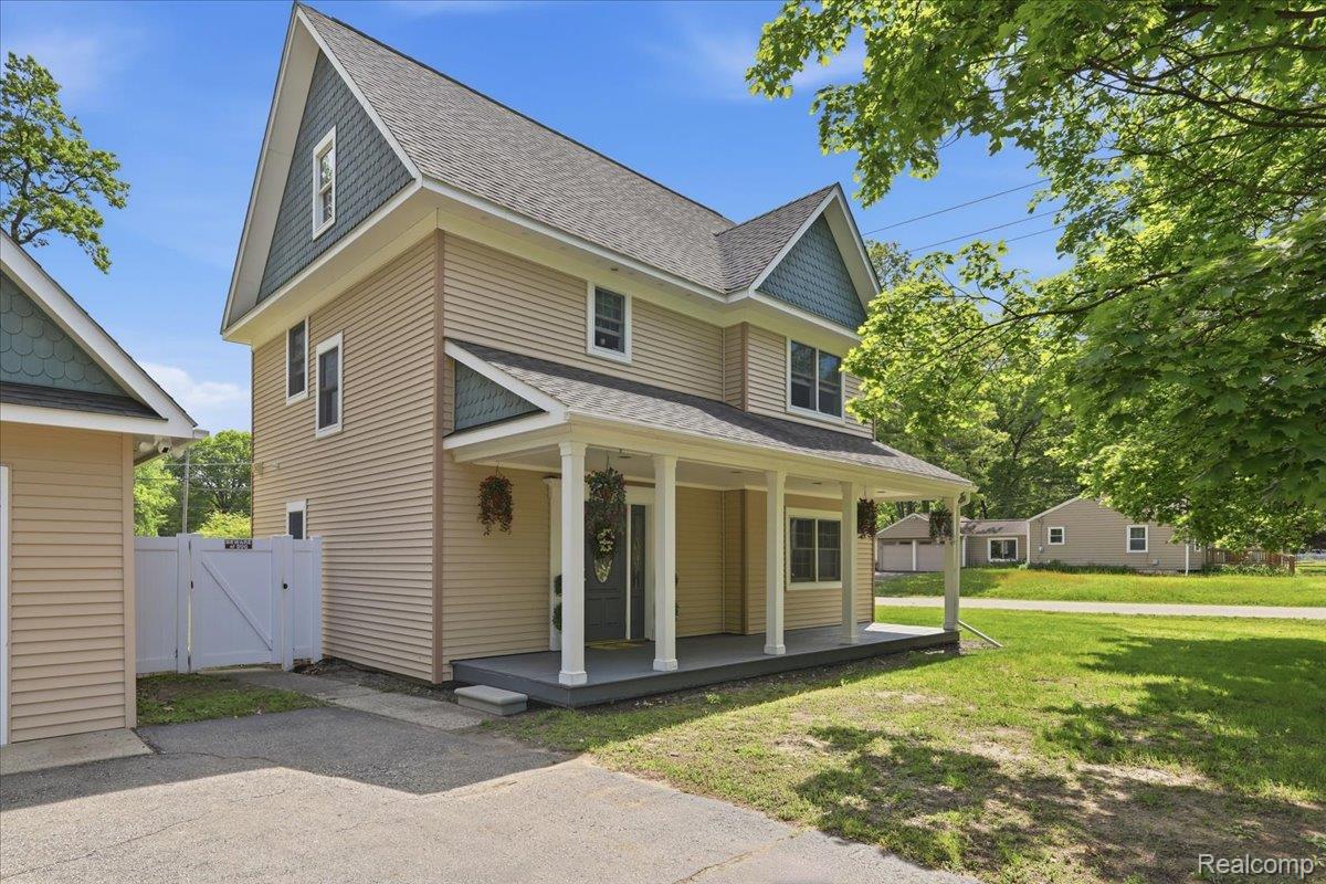 5685 Crescent Road Waterford, MI 48327 - Photo 4 of 47 Two-story residence featuring light-colored horizontal siding and a covered front porch with white columns