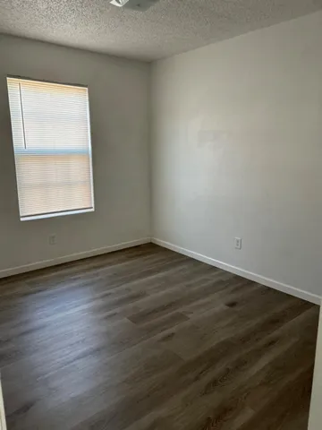 an empty room with wooden floor and a window