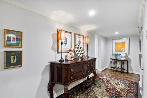 a bedroom with a bed chandelier and a window