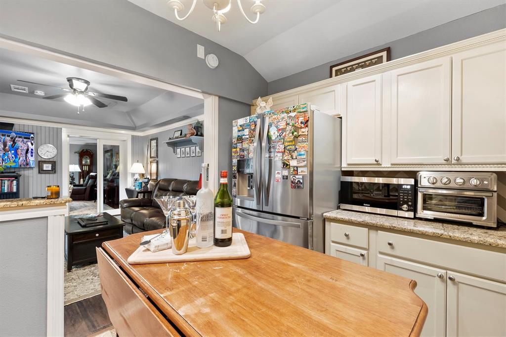 1432 Sylvan Avenue Dallas, TX 75208 - Photo 37 of 40 a kitchen with stainless steel appliances kitchen island granite countertop a refrigerator a stove top oven a dining table and chairs with wooden floor
