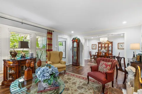 a dining room with furniture a kitchen and chandelier