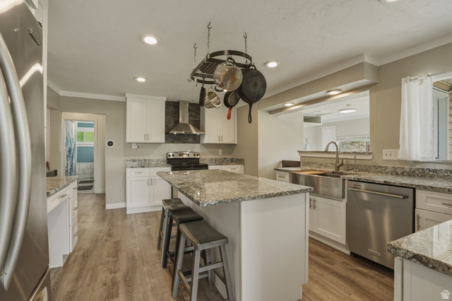 500 North 800 East Springville, UT 84663 - Photo 12 of 51 Kitchen with stainless steel appliances, a breakfast bar, a center island, light stone counters, and ornamental molding
