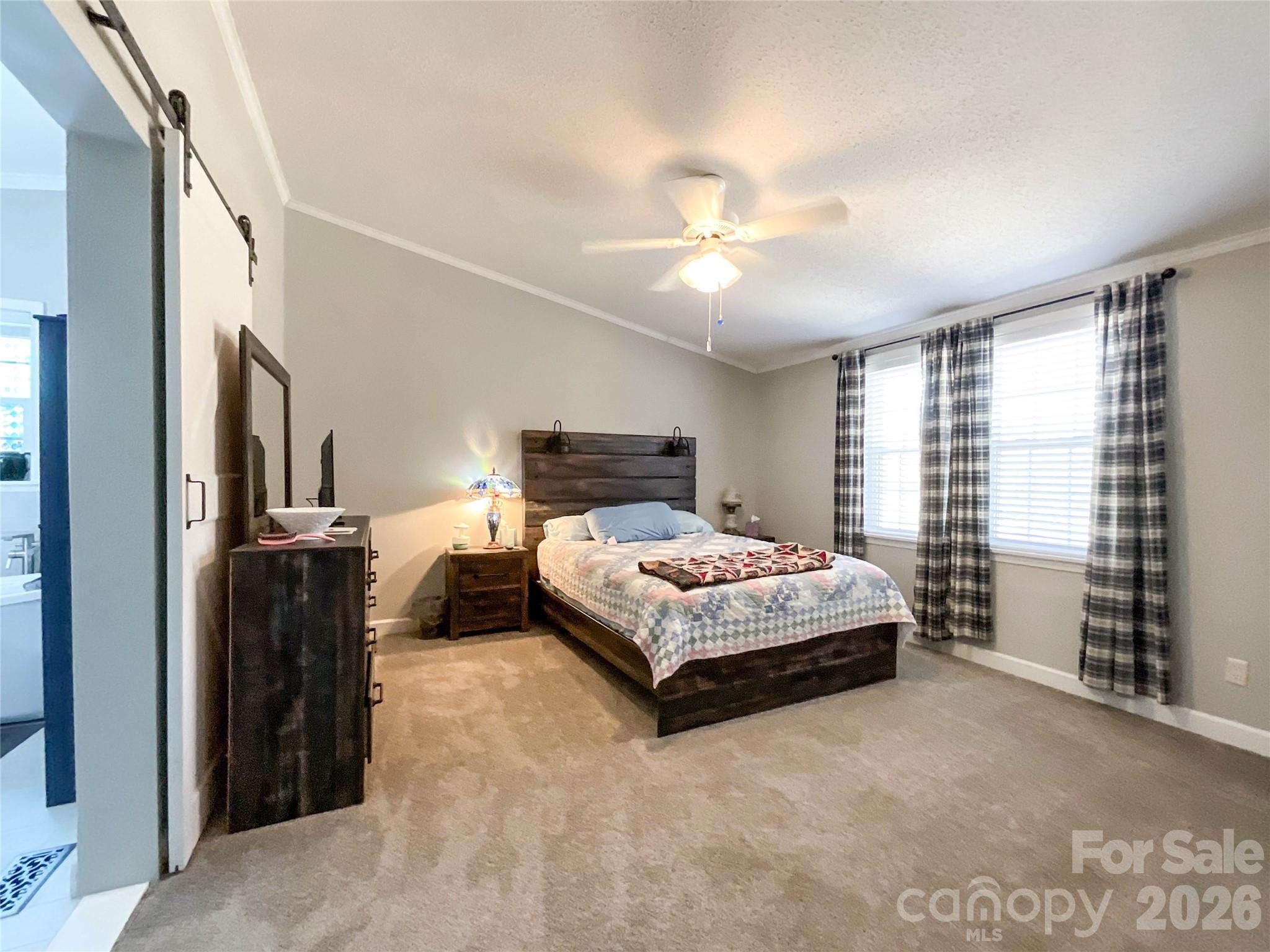 7706 Davis Road Waxhaw, NC 28173 - Photo 22 of 45 a bedroom with a large bed and a chandelier