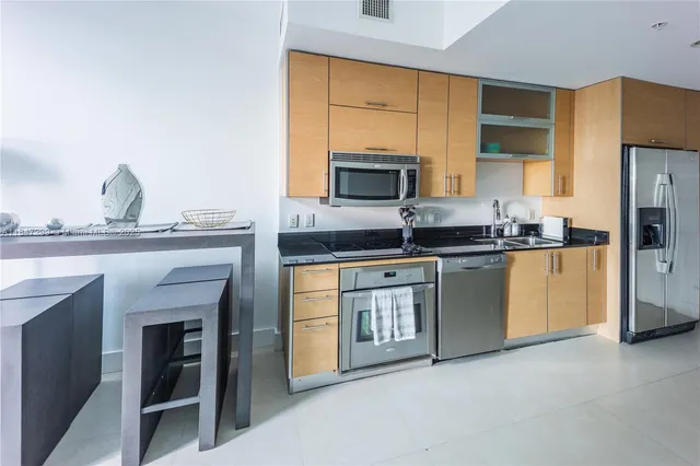 a kitchen with granite countertop a sink stainless steel appliances and cabinets