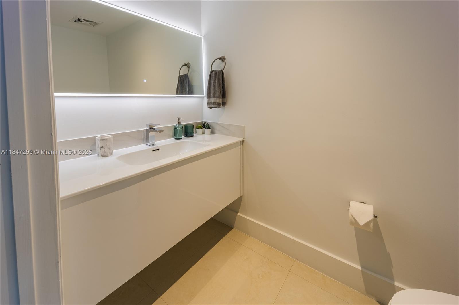 60 Southwest 13th Street, Unit 3222 Miami, FL 33130 - Photo 10 of 23 a bathroom with a sink and a mirror