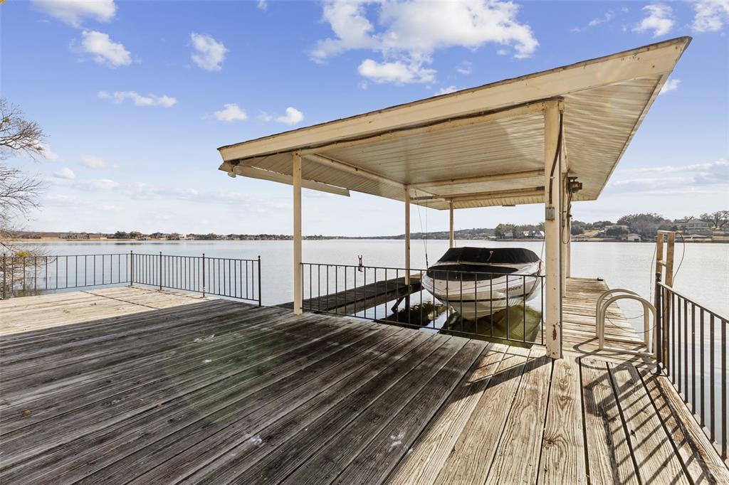 648 South Rough Creek Court Granbury, TX 76048 - Photo 9 of 26 a view of a balcony with chairs and wooden floor